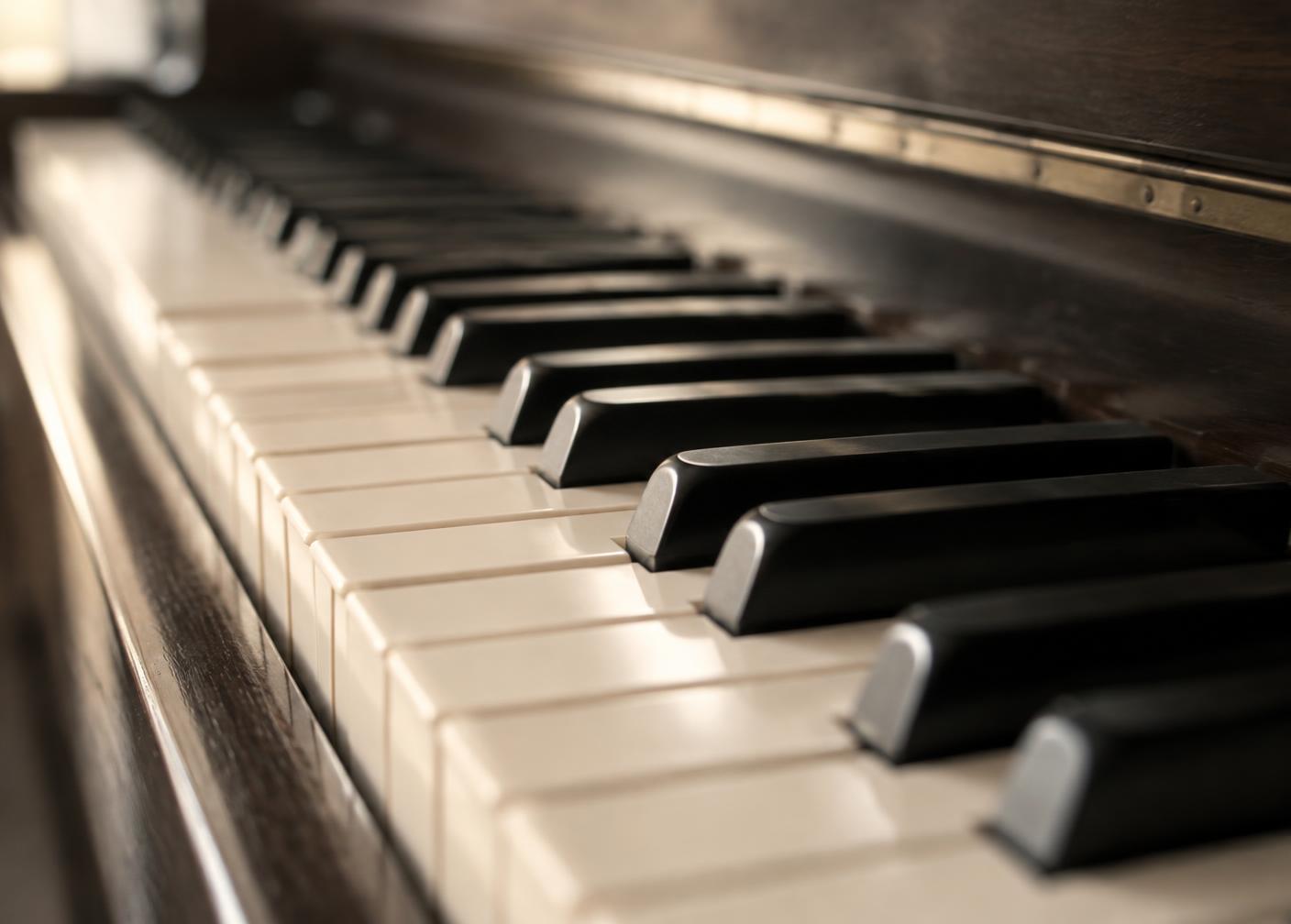 Detail of acoustic piano keys in warm daylight
